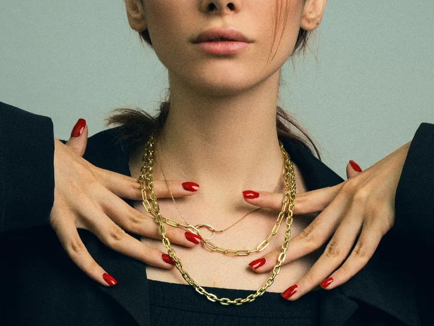 Layered gold-tone necklaces worn as fashion jewellery