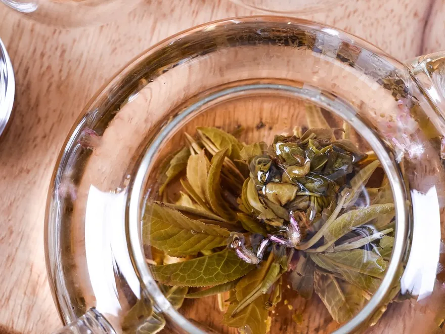Tea leaves opening in a glass teapot
